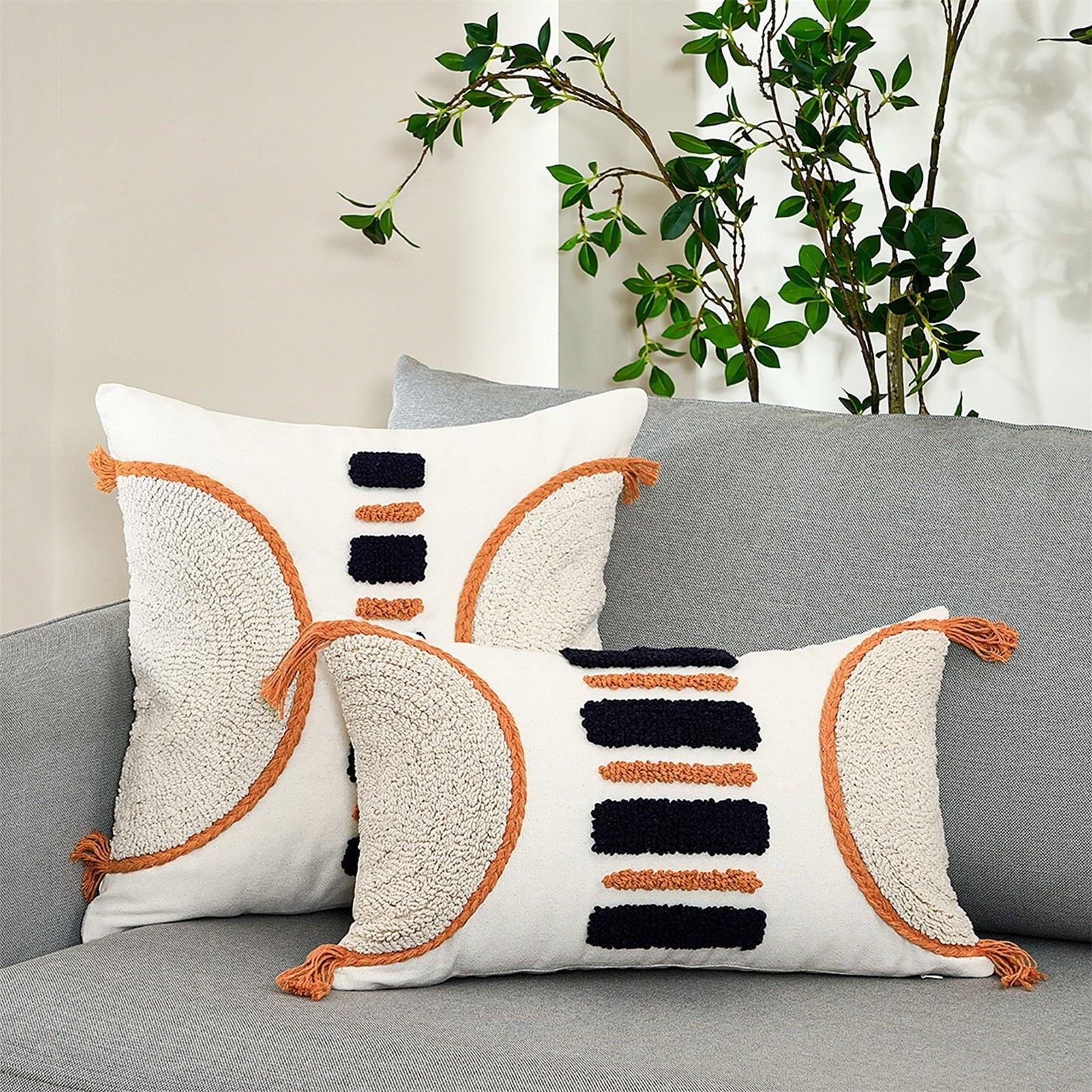 Cushion cover white tufted with orange piping and navy accents, tassel fringe on gray sofa on Tampa Home & Garden Store