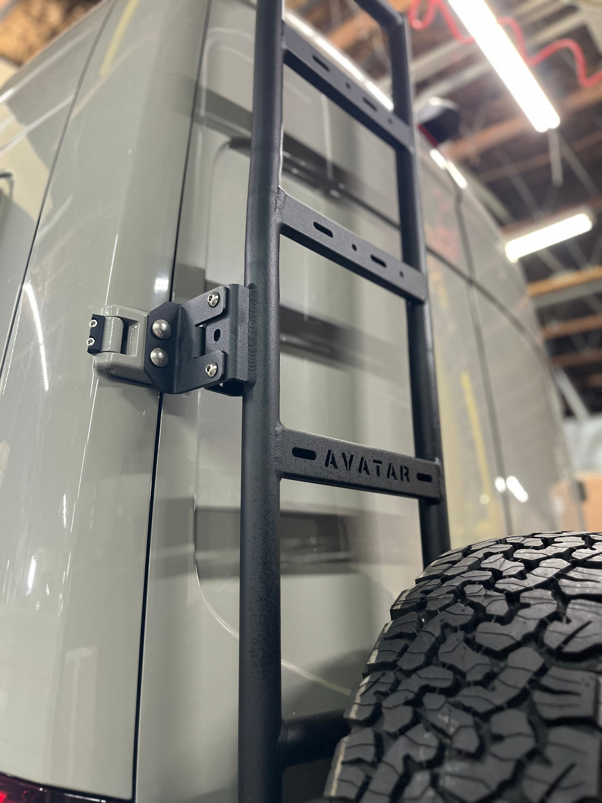 Avatar Van Rear Ladder Tire Carrier Mount on black steel frame with spare tire Avatar Offroad on Tampa Home & Garden Store