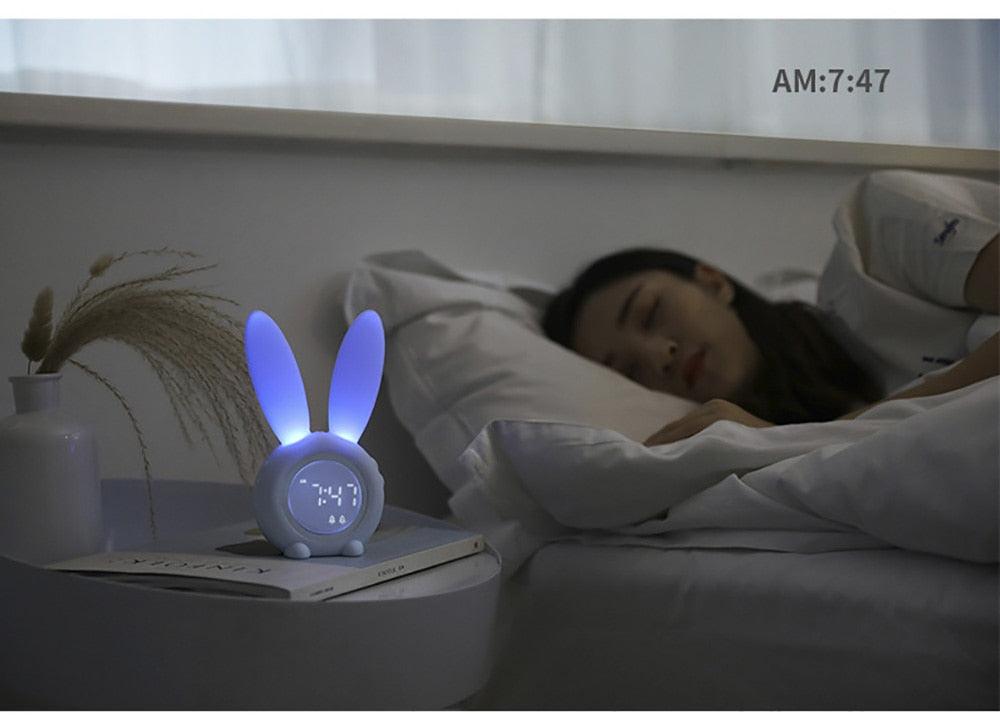 Cute bunny-ear LED alarm clock with blue glow on nightstand beside a sleeping child on Tampa Home & Garden Store