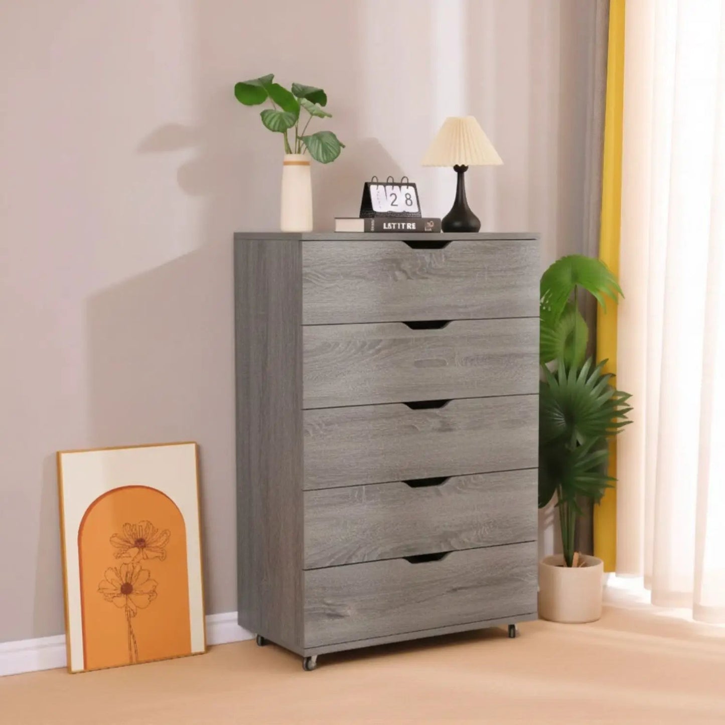 Modern 5-drawer dresser on wheels in gray wood finish with top vase, calendar, and lamp decor on Tampa Home & Garden Store