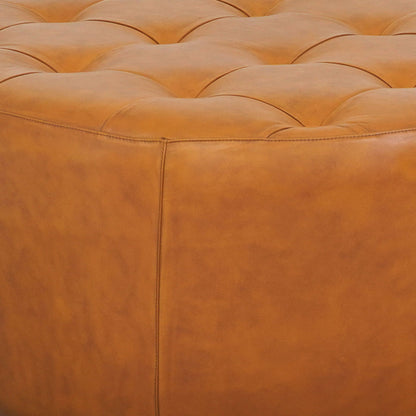 Light tan leather ottoman with tufted surface and stitched seams on Tampa Home & Garden Store