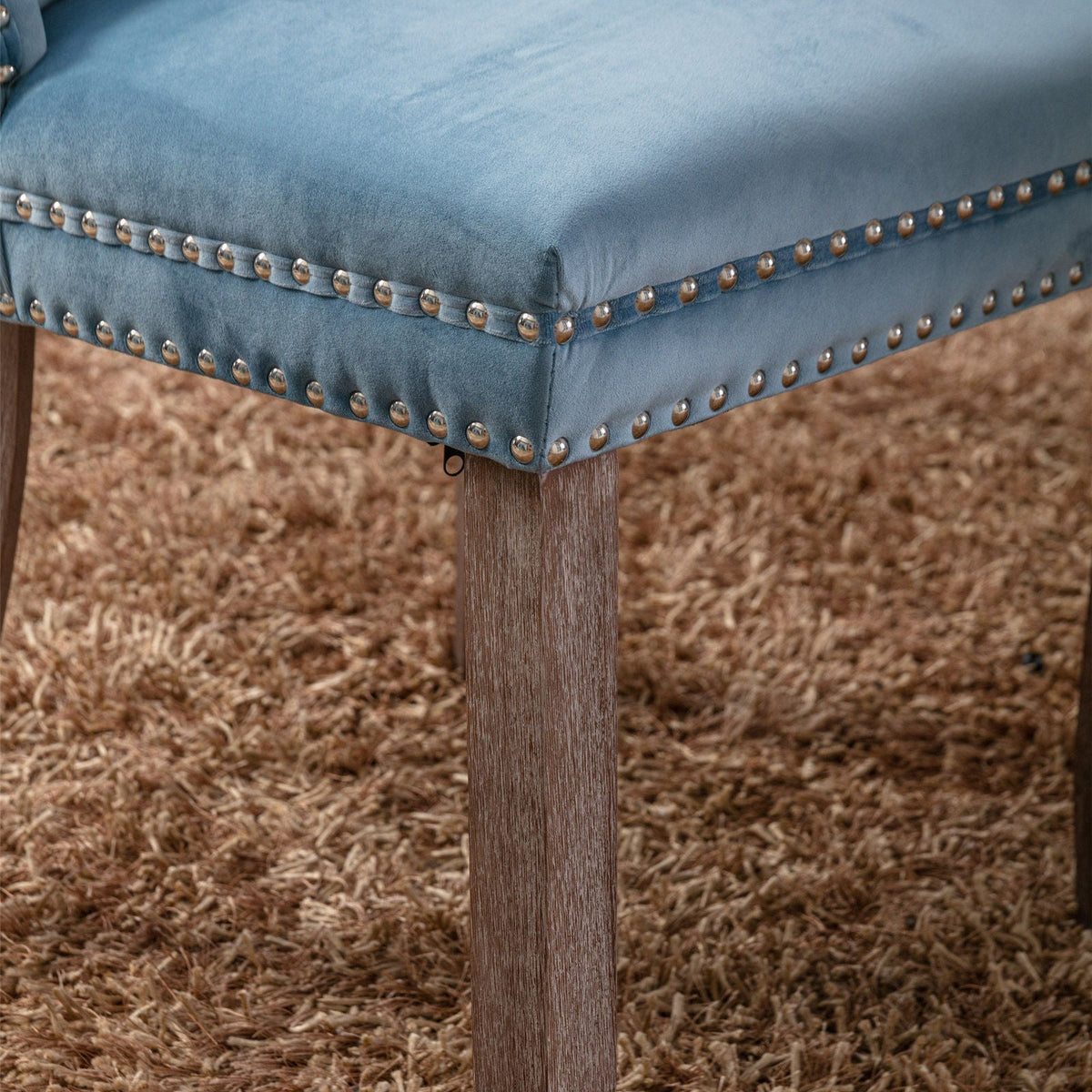 Tufted velvet dining chair with nailhead trim in blue, wooden legs on Tampa Home & Garden Store