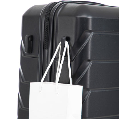 Black hard-shell luggage close-up with zipper edge and white shopping bag attached on Tampa Home & Garden Store