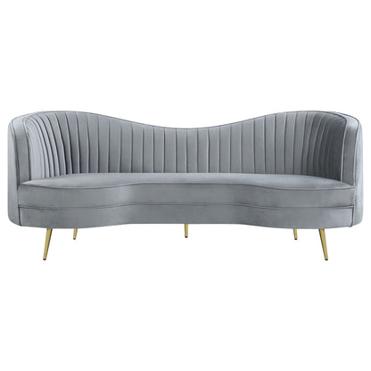 Reigha upholstered gray sofa with channel tufted backrest, curved arms, and gold legs on Tampa Home & Garden Store