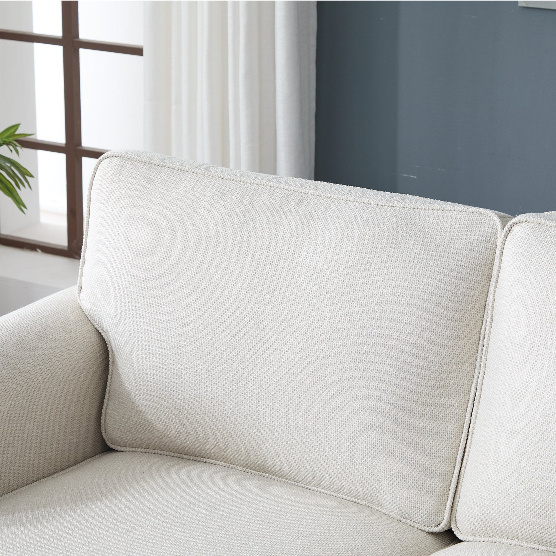 Beige fabric sofa with rounded rolled arm and piping edges on Tampa Home & Garden Store