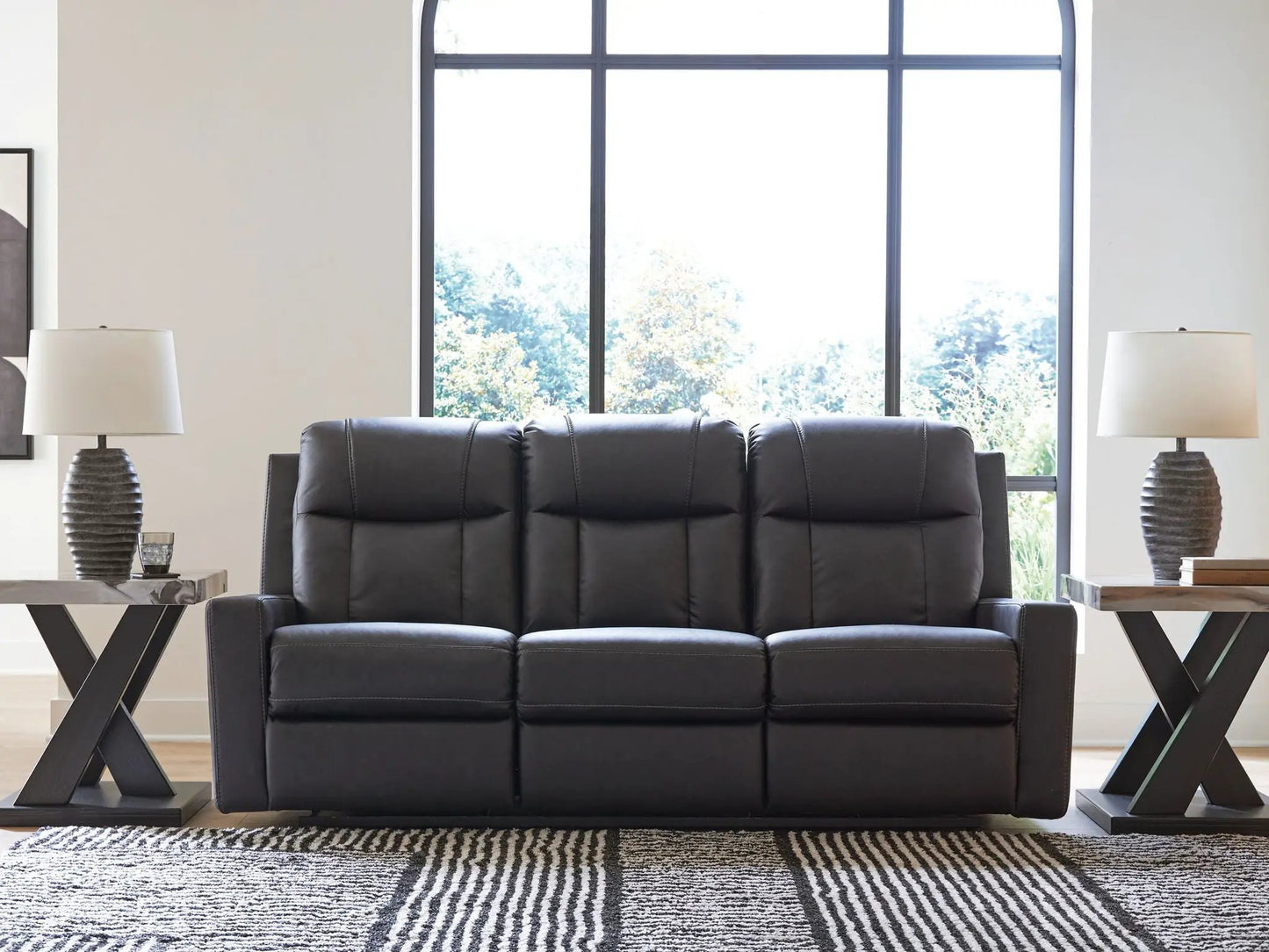 Mackmenville reclining sofa by Unique Piece Furniture in black leather with tufted cushions on Tampa Home & Garden Store