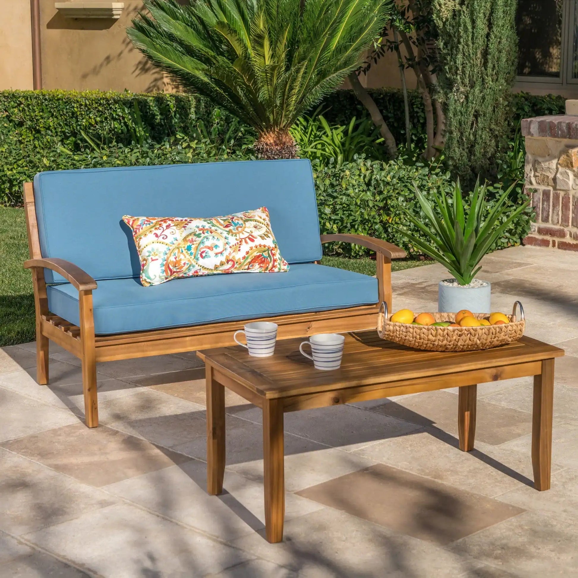 2-piece chat set with blue cushions loveseat and coffee table in a yard; fruit and mugs on Tampa Home & Garden Store