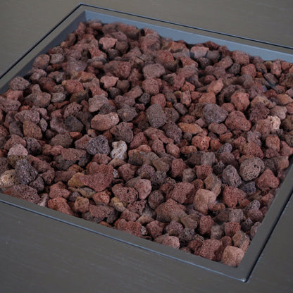 Outdoor propane fire pit with square iron frame filled with red lava rocks on Tampa Home & Garden Store