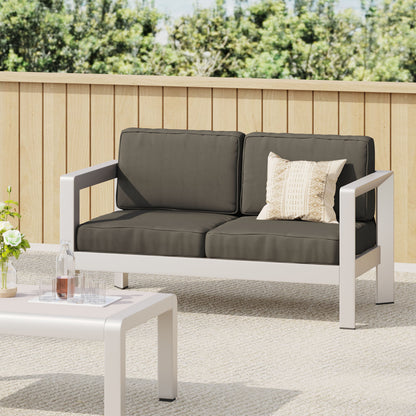 Outdoor aluminum loveseat with low-profile white frame and deep charcoal cushions on Tampa Home & Garden Store