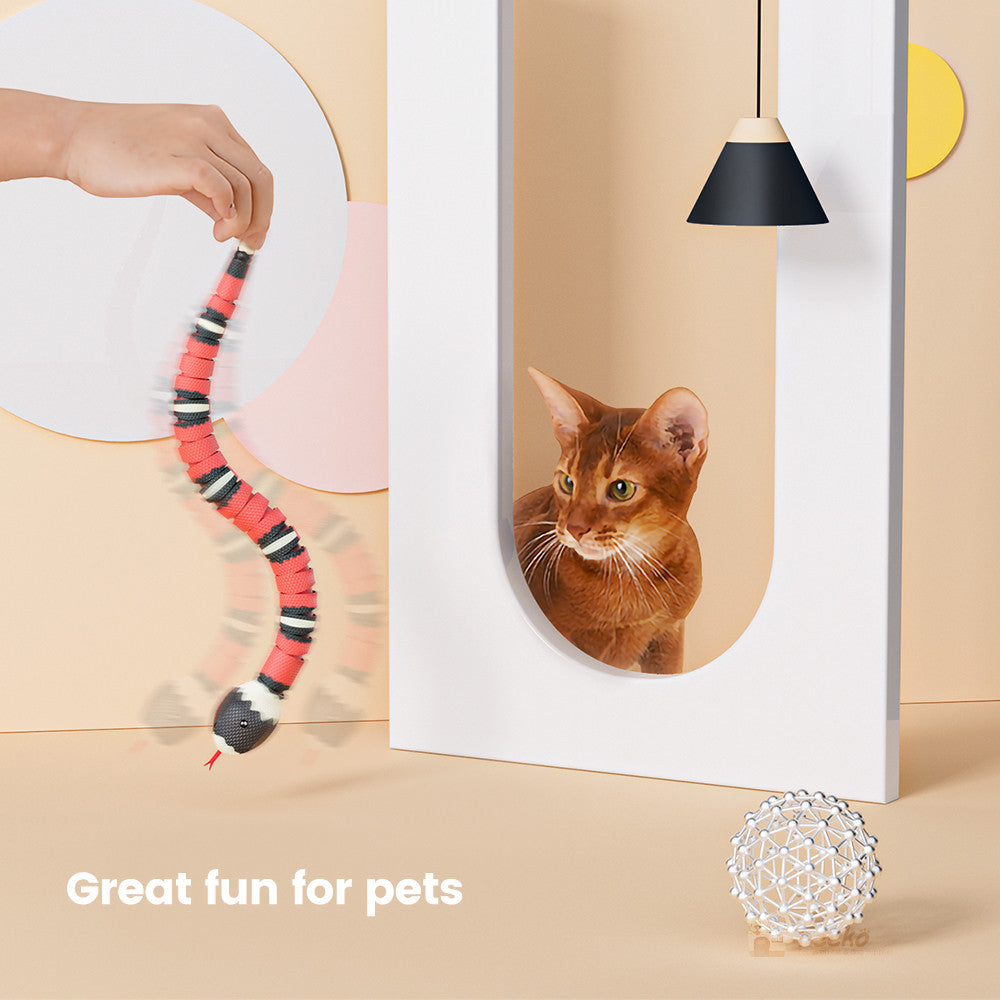 Tricky Electric Pink Snake Toy beside a curious cat in a white U-shaped pad holder Store on Tampa Home & Garden Store