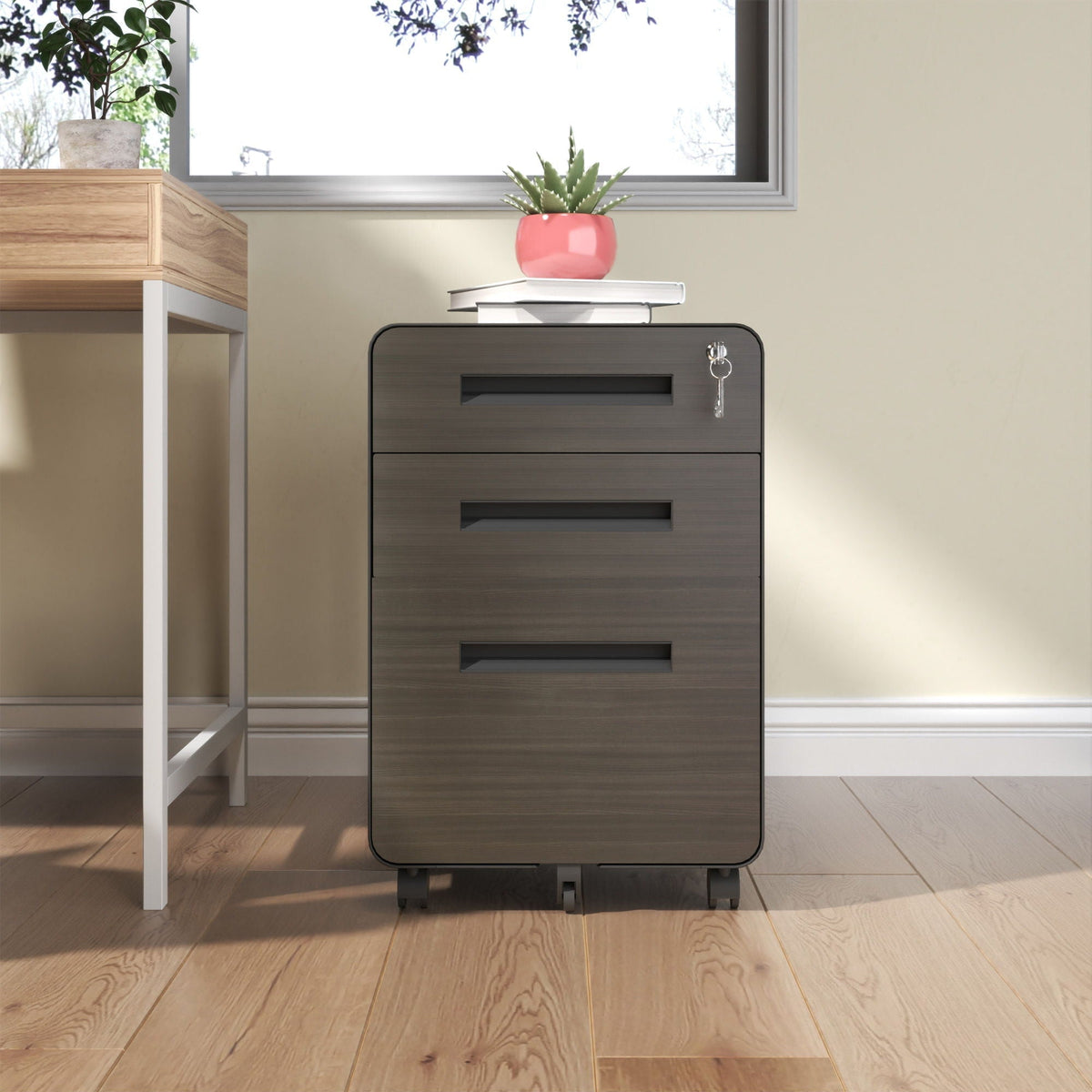 3-Drawer filing cabinet in black with lock and casters, topped by books and a pink succulent on Tampa Home & Garden Store