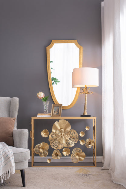 Gold leaf table lamp with white shade on a gold console table with bold floral decor on Tampa Home & Garden Store