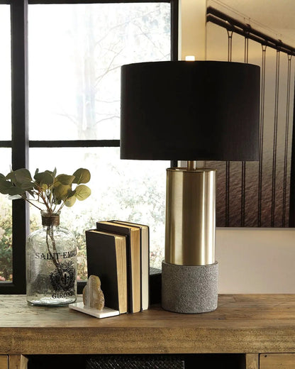 Jacek metal table lamp with black drum shade, brass cylindrical base atop concrete pedestal on Tampa Home & Garden Store