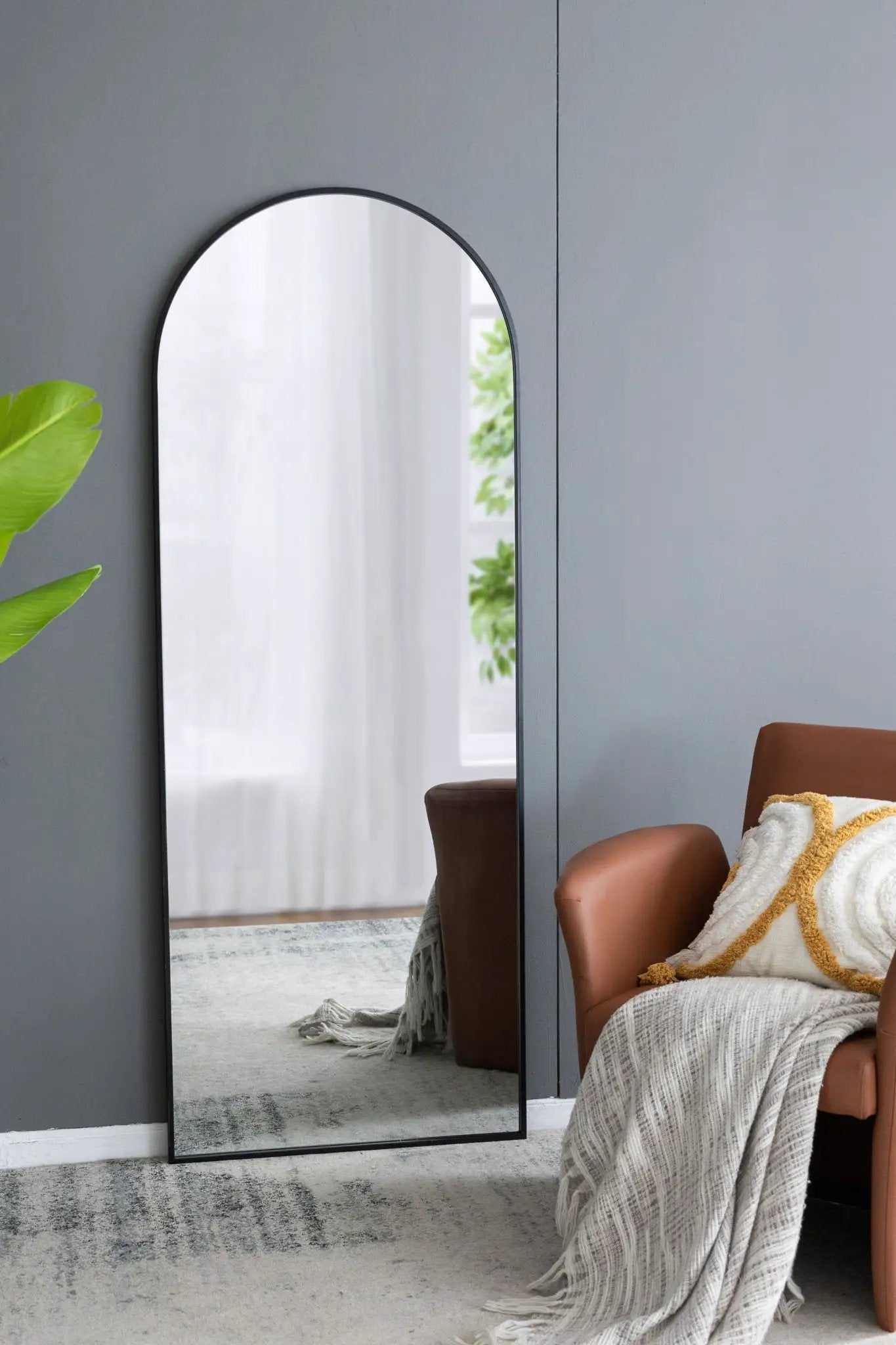 Celine Arch Body Mirror floor mirror with slim black arched frame leaning against a wall on Tampa Home & Garden Store