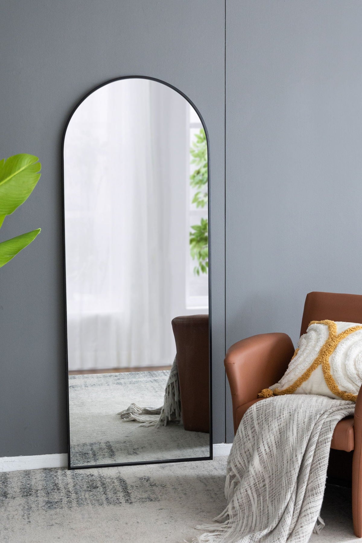 The Celine Arch Body Mirror by HouseOfZazla, slim black arched mirror leaning against wall on Tampa Home & Garden Store