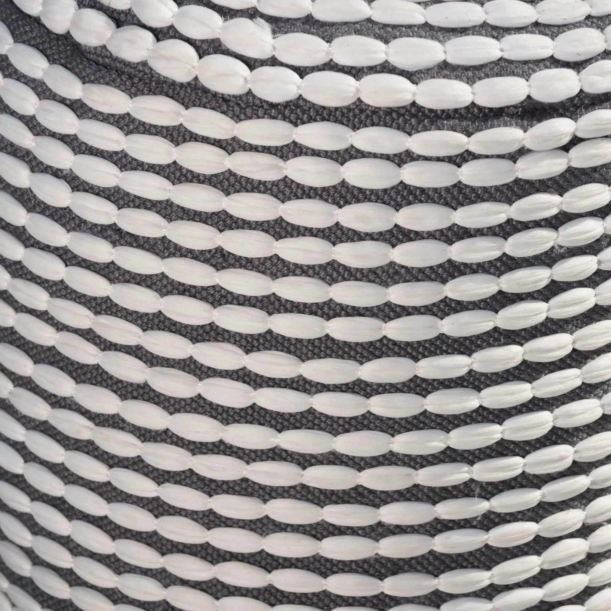 River cylindrical pouf with white bead detailing on dark woven fabric on Tampa Home & Garden Store