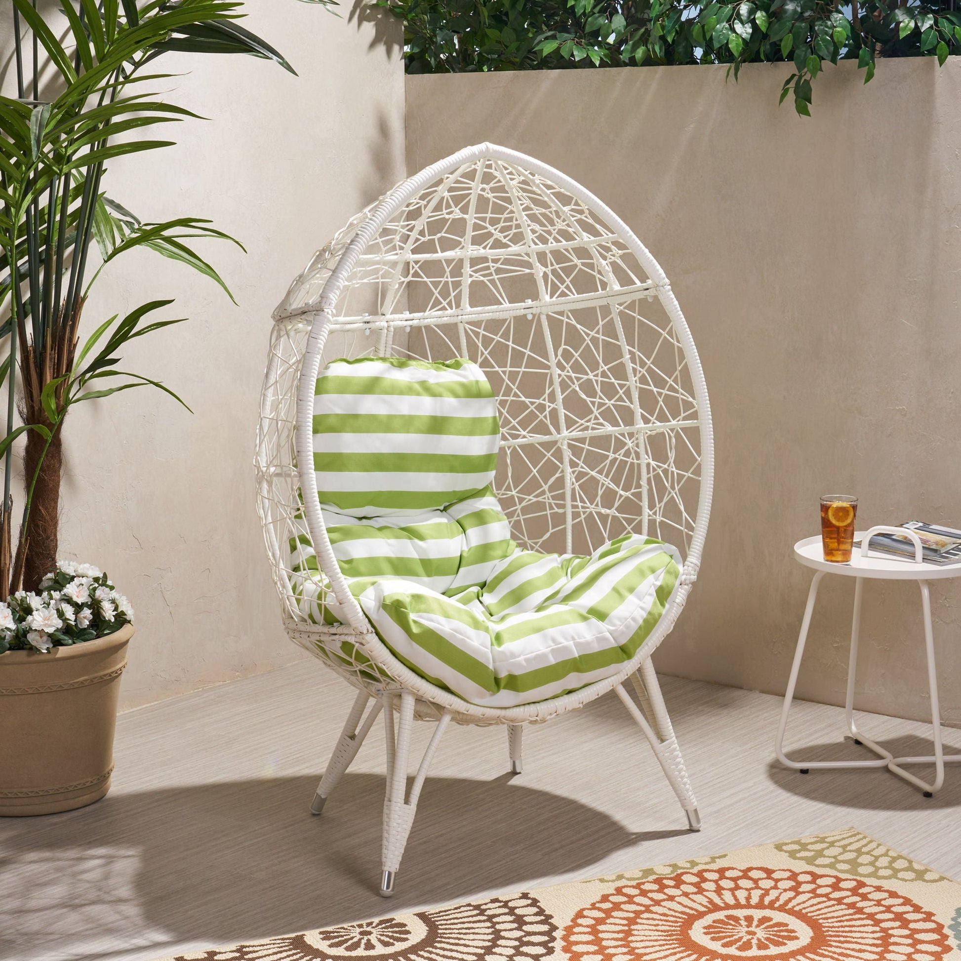 Cosmos Round Hammered Iron Teardrop Chair with green striped cushion, seating on Tampa Home & Garden Store