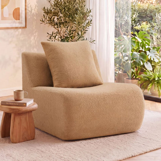 Armless teddy camel fabric sofa with pillow; plush rounded seat beside a wooden side table on Tampa Home & Garden Store