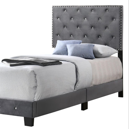 Luxurious upholstered bed with gray tufted headboard and nailhead trim on dark legs on Tampa Home & Garden Store