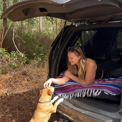 Umbrauto SUV air mattress 1.0 black laid in trunk with blanket; woman relaxing dog approaches on Tampa Home & Garden Store