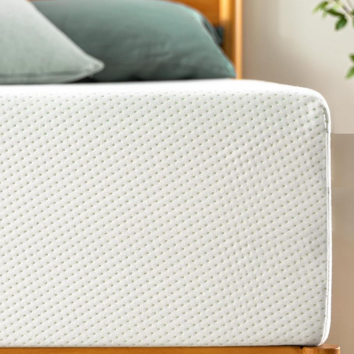 10-inch queen size mattress with white dotted cover and green pillows on a wooden bed frame on Tampa Home & Garden Store