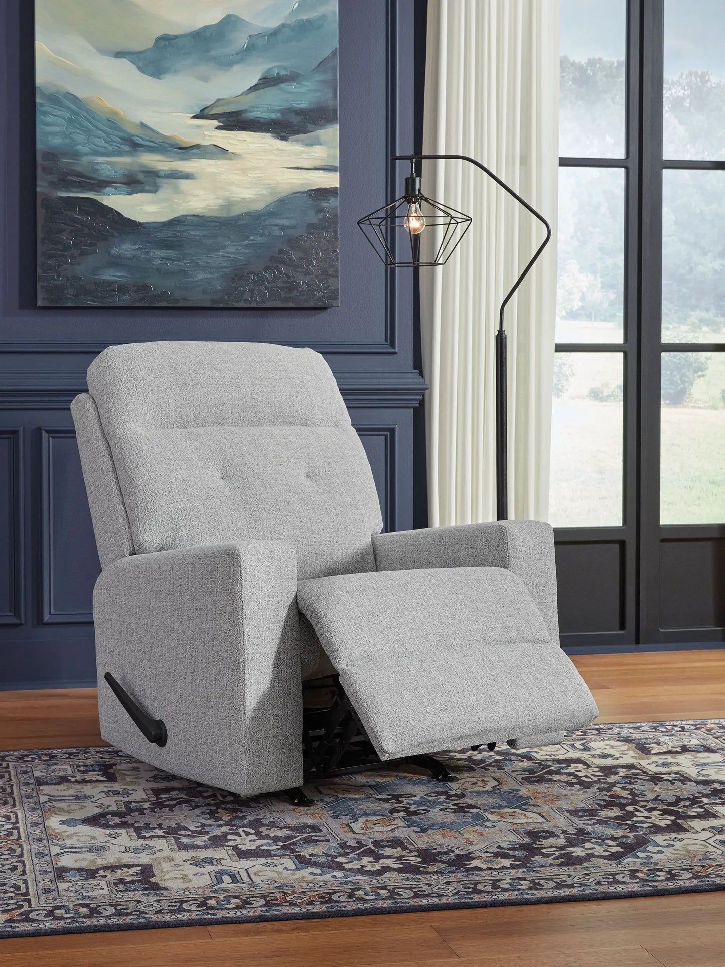 Skillins Rocker Recliner Stone fabric with footrest in a navy-paneled living room beside a geometric black lamp on Tampa Home & Garden Store