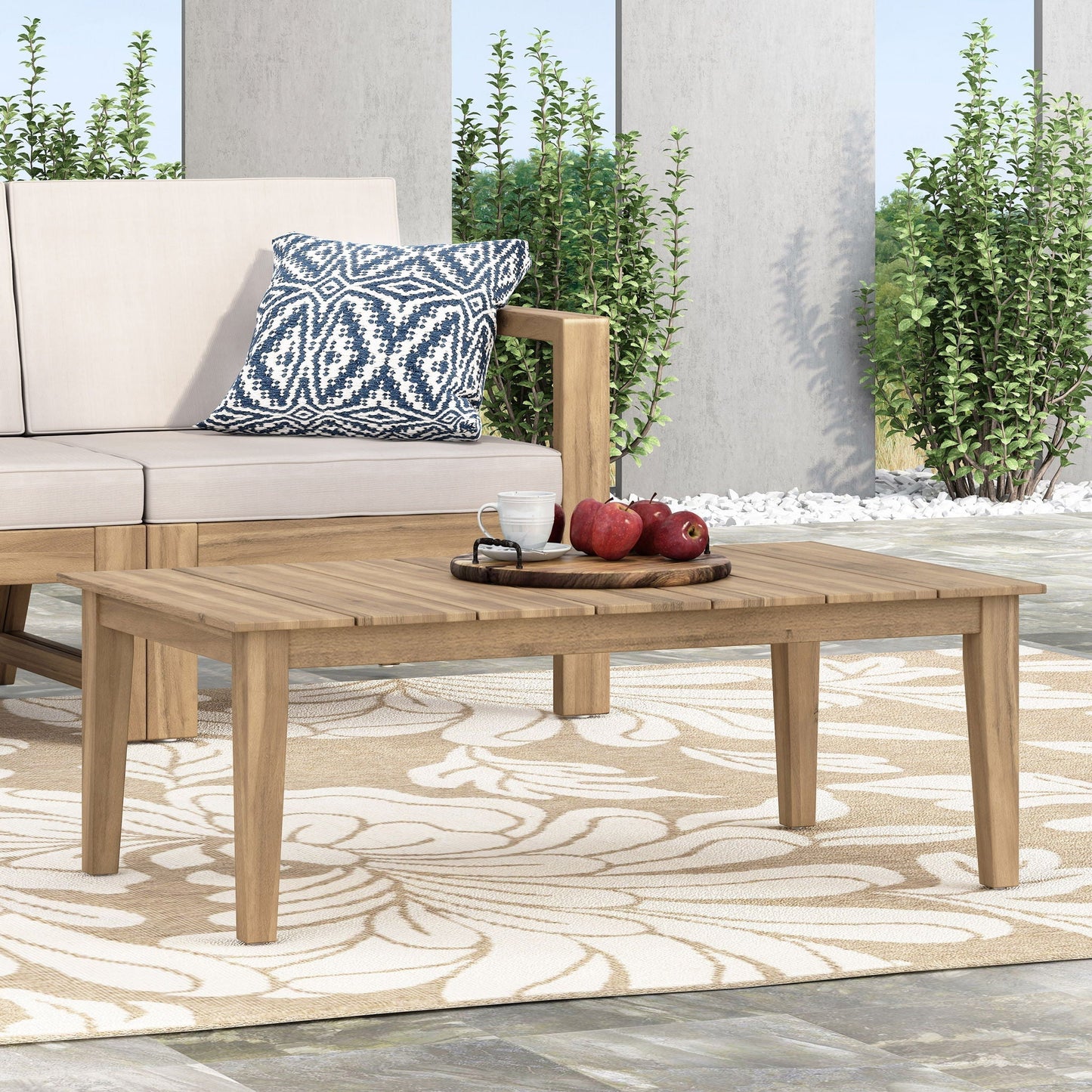 Outdoor coffee table with slat panel top in light brown wood, beige cushioned seating on patio on Tampa Home & Garden Store