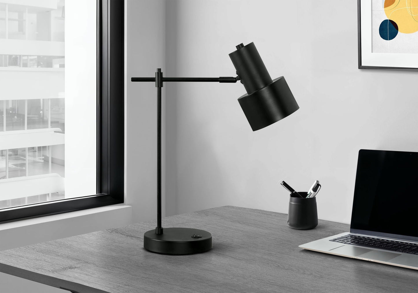 Black metal table lamp with adjustable arm on a desk beside a laptop in a modern office setting on Tampa Home & Garden Store