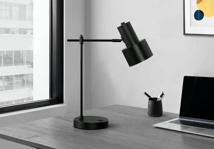 Black metal table lamp with adjustable arm on a desk beside a laptop in a modern office setting on Tampa Home & Garden Store
