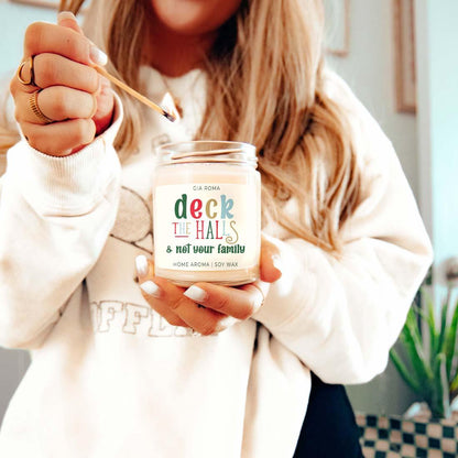 Deck The Halls Candle in a glass jar with Gia Roma label, lit by a wooden match on Tampa Home & Garden Store