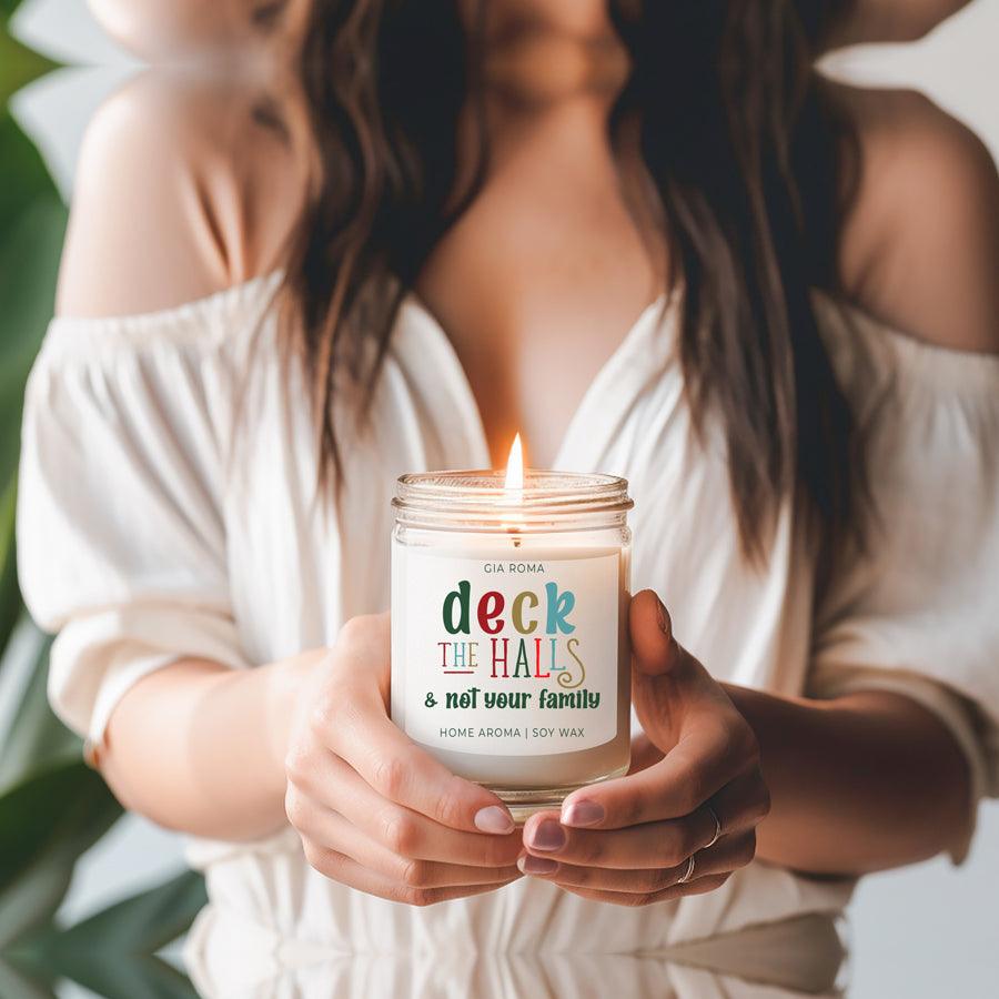 Deck The Halls Candle by Gia Roma in a clear glass jar with a colorful label and lit wick on Tampa Home & Garden Store