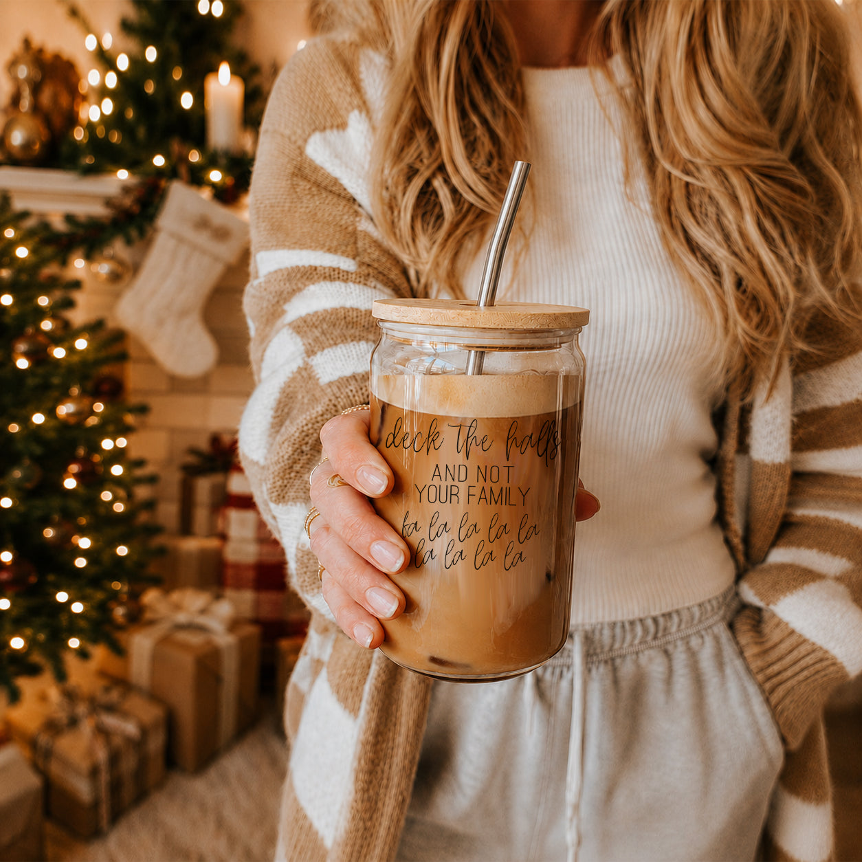 Deck the Halls 17oz glass cup with bamboo lid and metal straw Gia Roma drinkware held by a person on Tampa Home & Garden Store