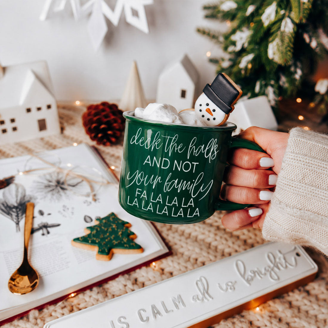 Deck The Halls mug by Gia Roma, green ceramic mug with marshmallows and a snowman cookie on rim on Tampa Home & Garden Store