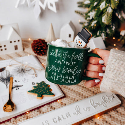 Deck The Halls mug by Gia Roma, green ceramic mug with marshmallows and a snowman cookie on rim on Tampa Home & Garden Store