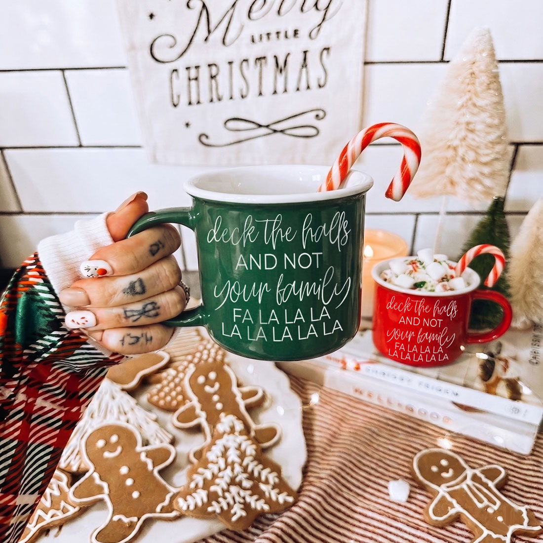 Green Gia Roma Deck The Halls coffee mug with white script and candy cane; red mug nearby on Tampa Home & Garden Store