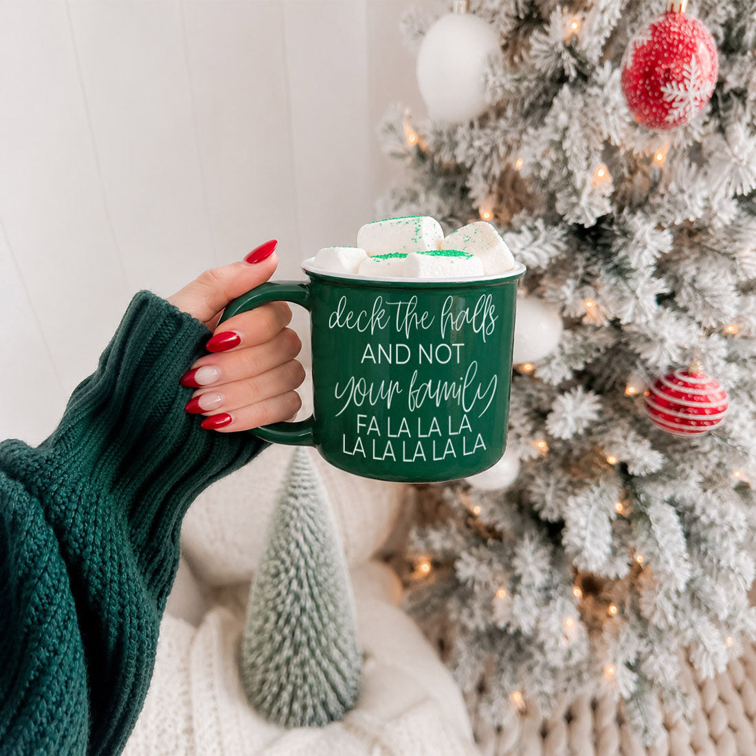 Green Gia Roma Deck The Halls coffee mug with marshmallows, holiday tree backdrop on Tampa Home & Garden Store