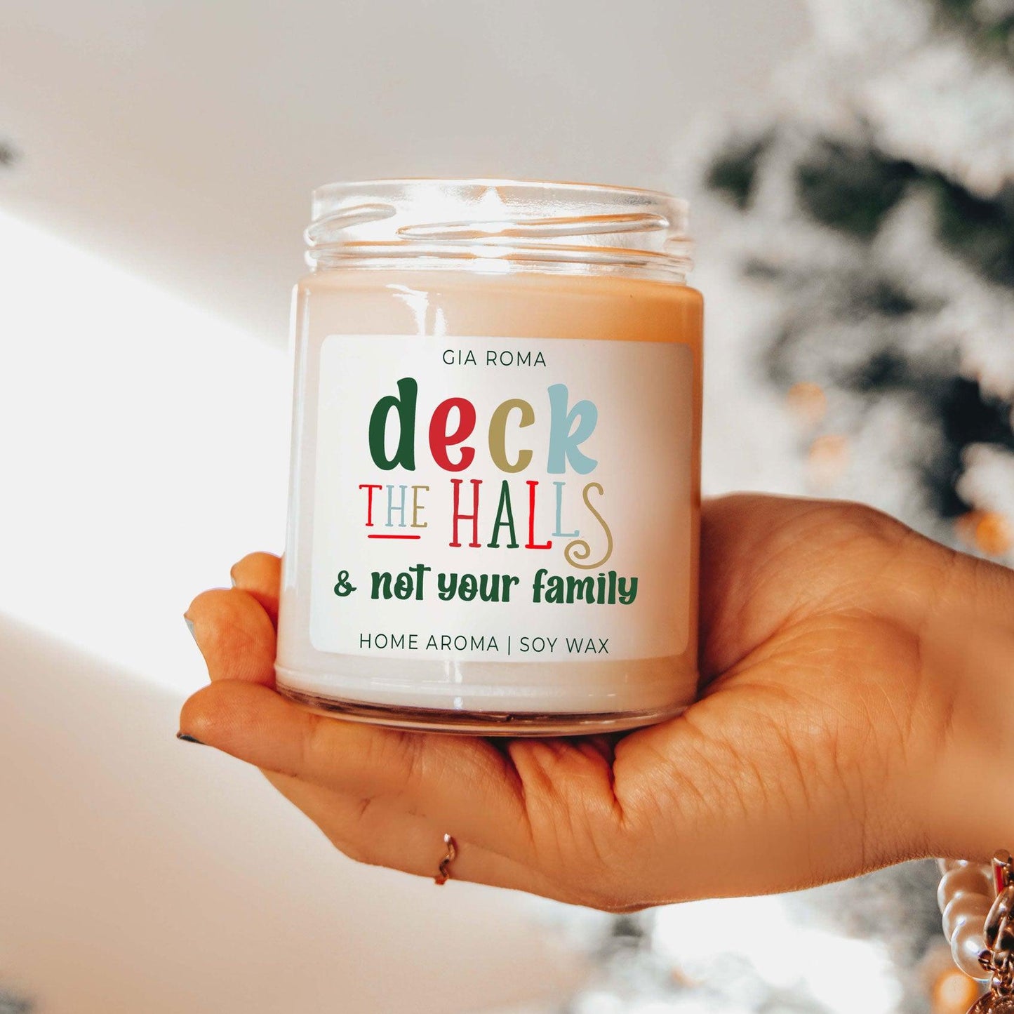 Deck The Halls candle by Gia Roma, peach soy wax in a clear glass jar, hand held on Tampa Home & Garden Store