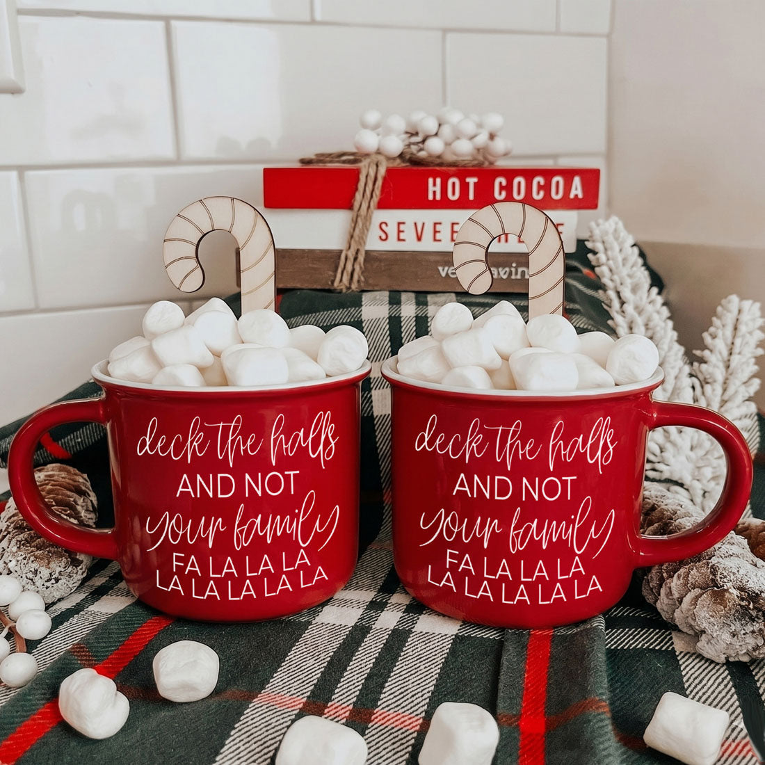 Pair of Gia Roma red Deck The Halls mugs with white script lettering, stuffed with marshmallows on Tampa Home & Garden Store