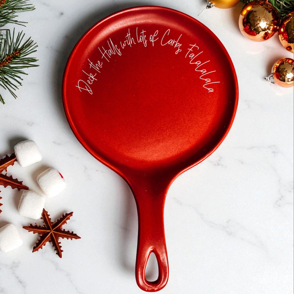 Deck the Halls & Carbs spoon rest red with white cursive print, round with handle on Tampa Home & Garden Store