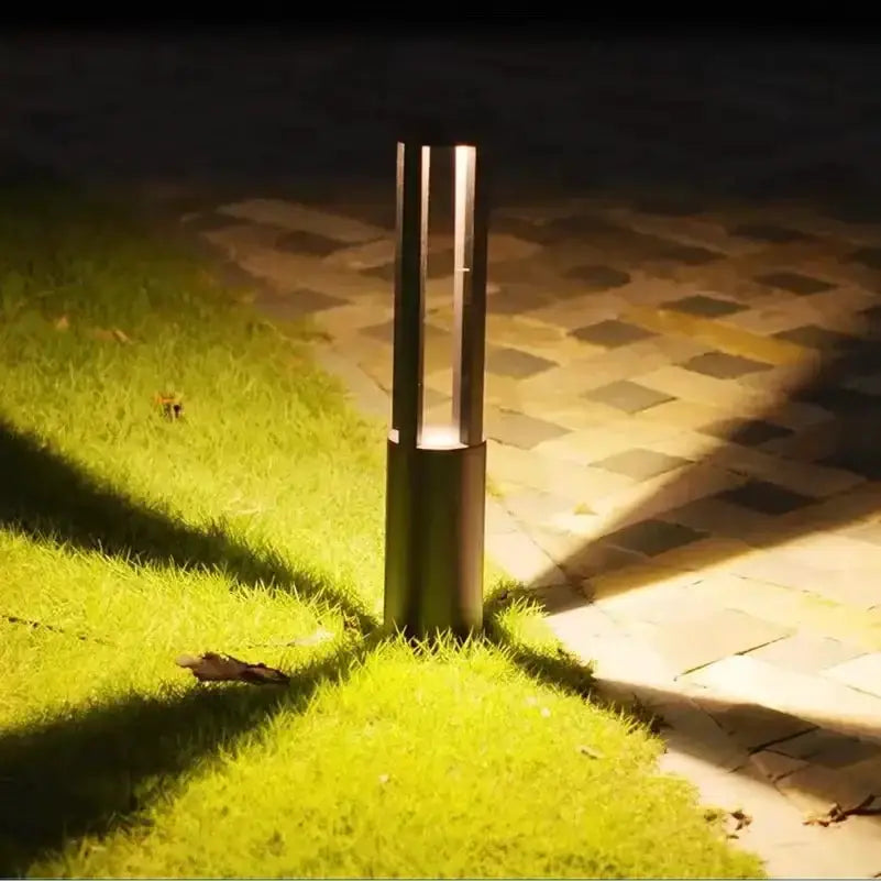 Decorbites modern gold aluminum LED garden path lamp bollard light along brick walkway at night on Tampa Home & Garden Store