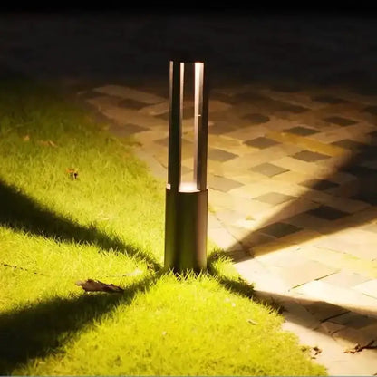 Decorbites modern gold aluminum LED garden path lamp bollard light along brick walkway at night on Tampa Home & Garden Store