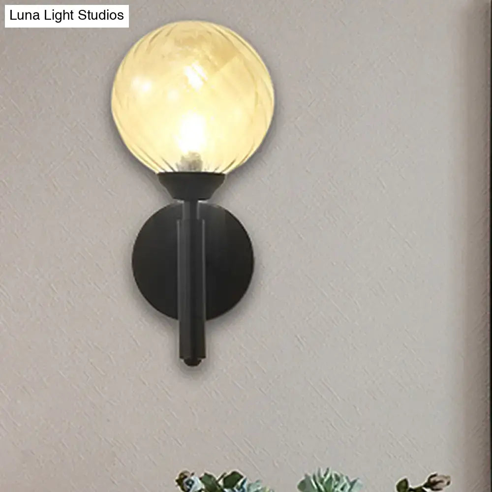 Decorbites black textured glass sconce with circular backplate and vertical stem, warm glow on Tampa Home & Garden Store