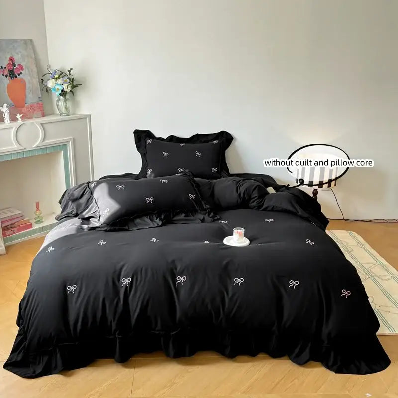 Decorbites black duvet cover set with white bow embroidery and ruffled edges on bed on Tampa Home & Garden Store