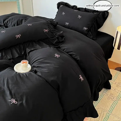 Black duvet cover set with pink bow embroidery and ruffled edges, matching shams in a bedroom on Tampa Home & Garden Store