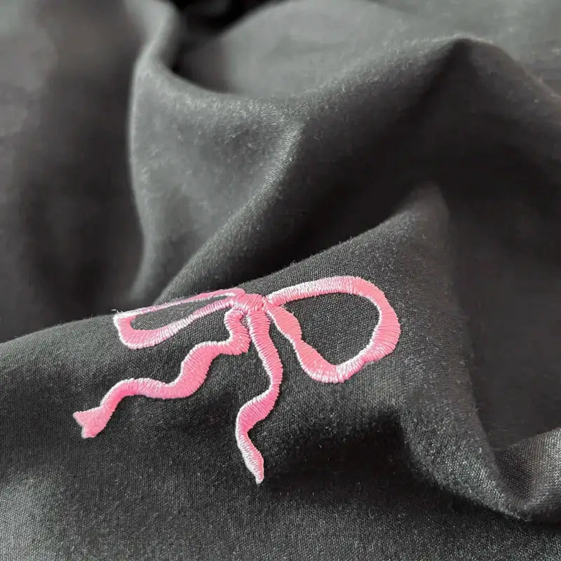 Black duvet cover with pink bow embroidery close-up fabric detail on Tampa Home & Garden Store