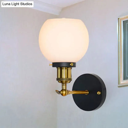 Decorbites brass bubble glass wall sconce with frosted globe and black backplate on Tampa Home & Garden Store