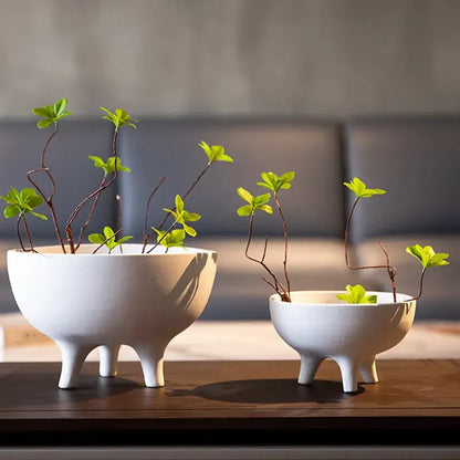 White ceramic tripod planter pair in two sizes with green leafy stems by Decorbites on Tampa Home & Garden Store