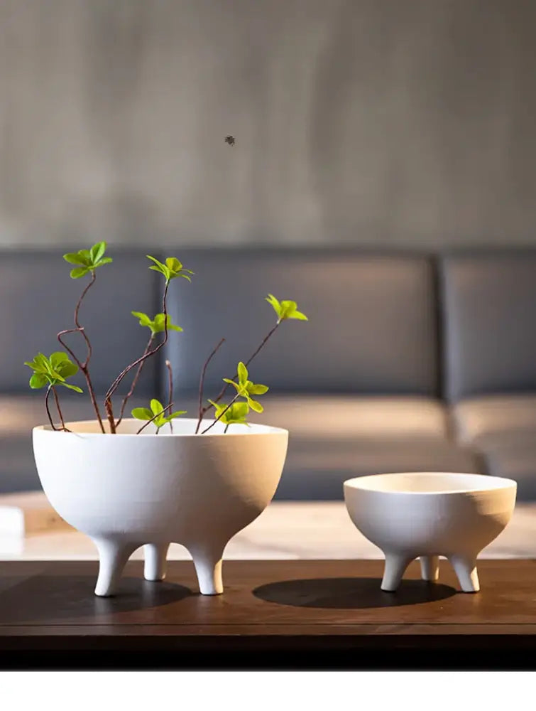 Two white ceramic tripod planters by Decorbites; large bowl with plant and small pot on Tampa Home & Garden Store