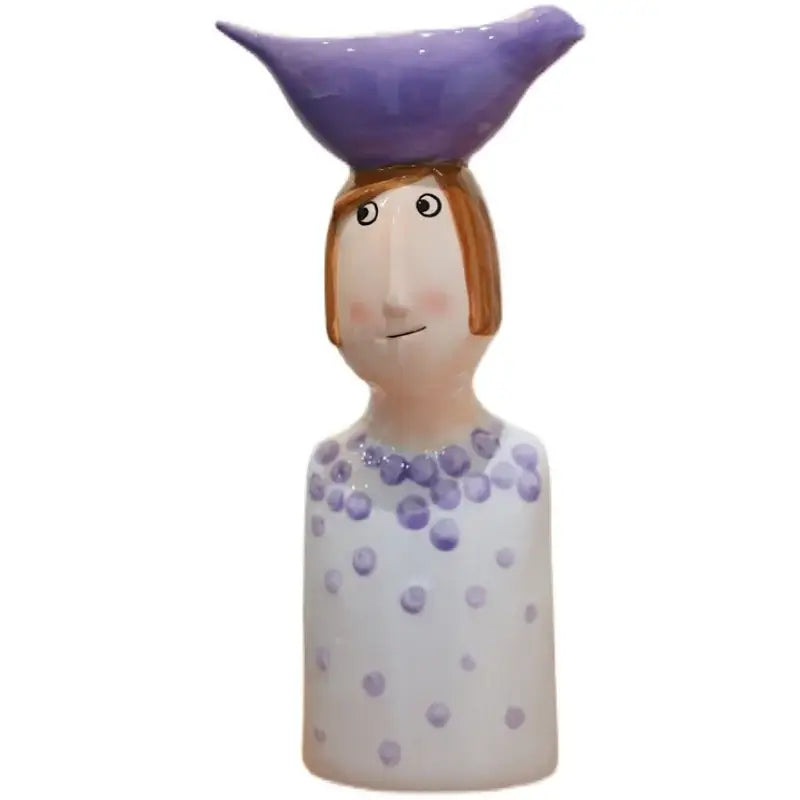 Blue ceramic vase by Decorbites, whimsical figure with purple hat and lavender dress on Tampa Home & Garden Store