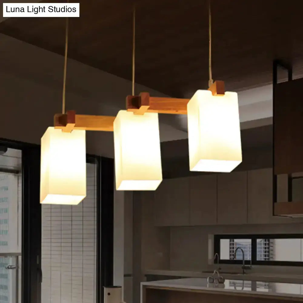 Wood and white glass 3 pendant kitchen light with frosted rectangular shades on a wood bar on Tampa Home & Garden Store